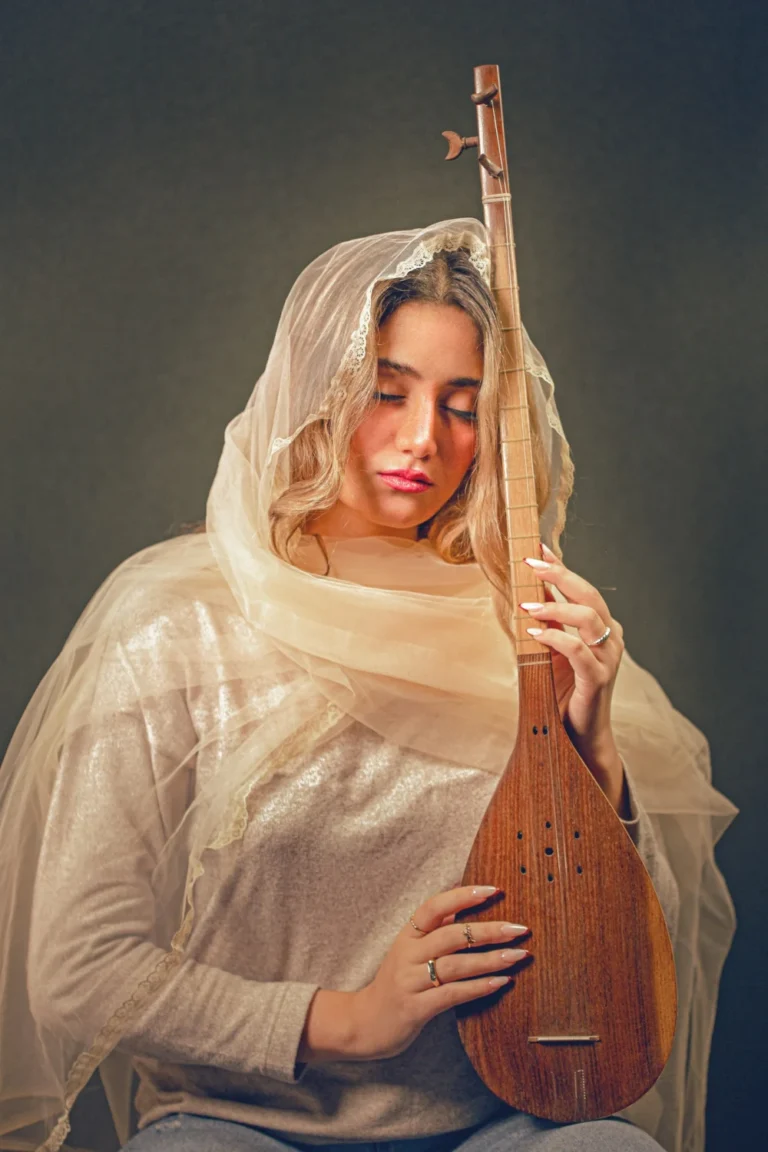زنی با ساز زهی ایرانی در دست، در نور ملایم